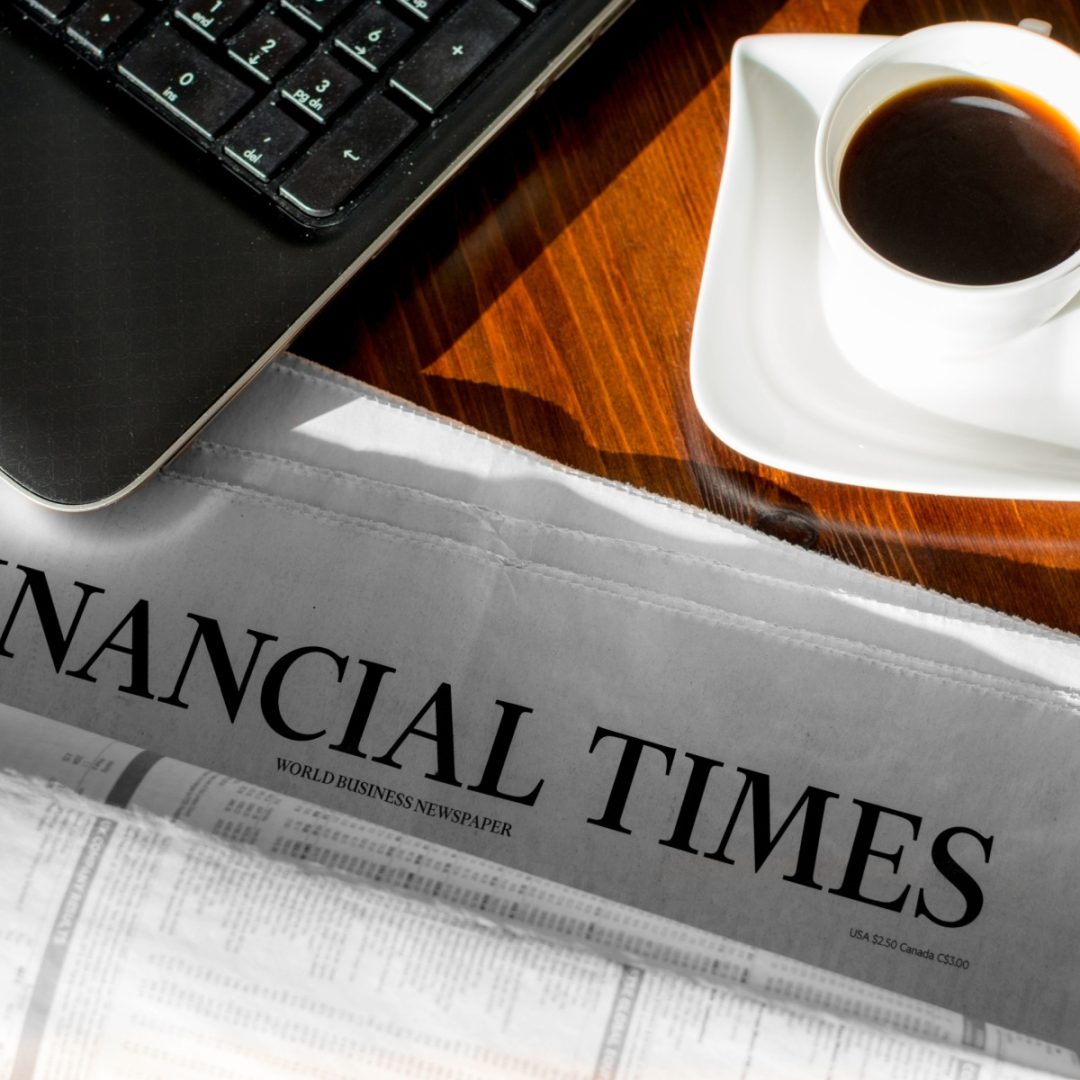 Financial Times paper on desk with coffee and keyboard